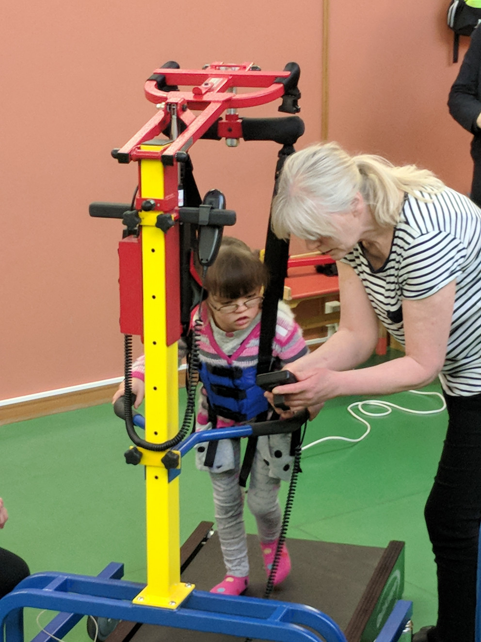 Katrín Sara og Rósa sjúkraþjálfari sýna Trausta og göngubrettið Gönguhrólf í notkun.